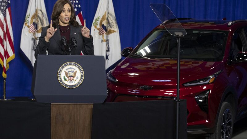 Vice President Kamala Harris gives a speech in front of a red electric vehicle. | Michael Reynolds - Pool via CNP/picture alliance / Consolidated News Photos/Newscom