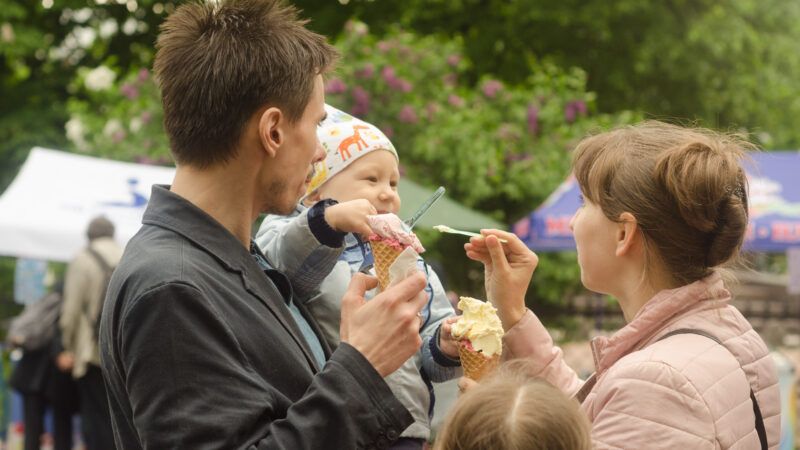 A young couple feeds ice cream to their infant. | Andrej Mitin | Dreamstime.com 