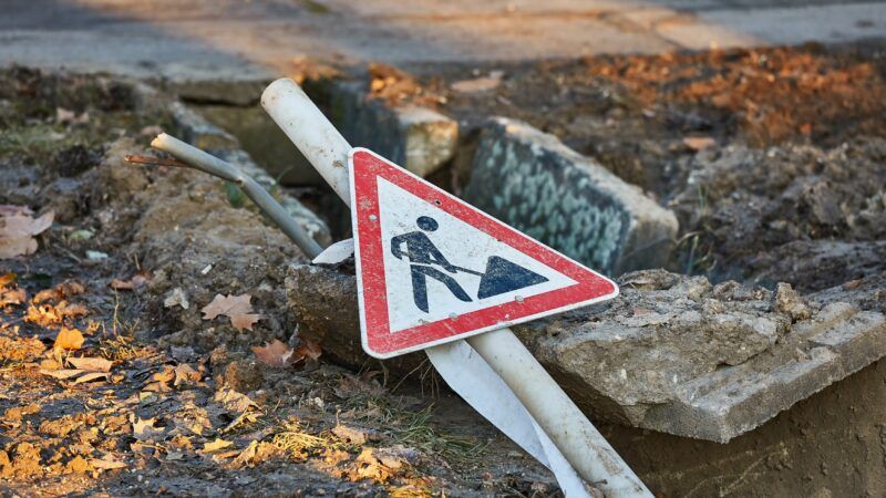 A road work sign lays on the ground | Gudella/Newscom