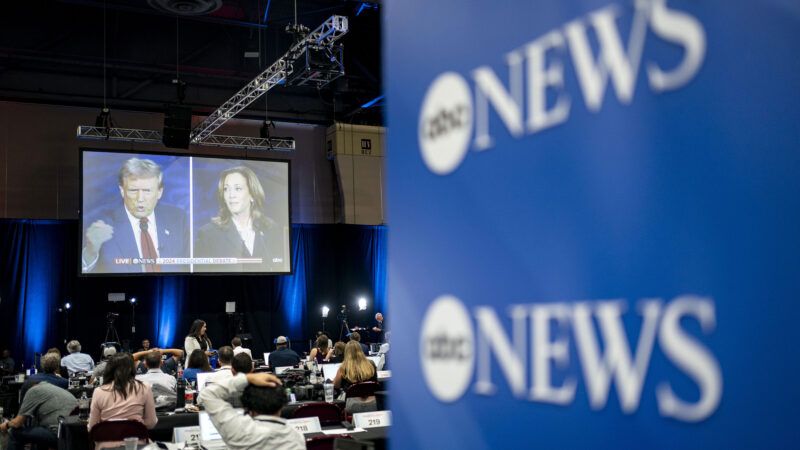 Trump and Harris debate shown on a screen in a room full of people seated at tables with the ABC News logo on display. | BONNIE CASH/UPI/Newscom