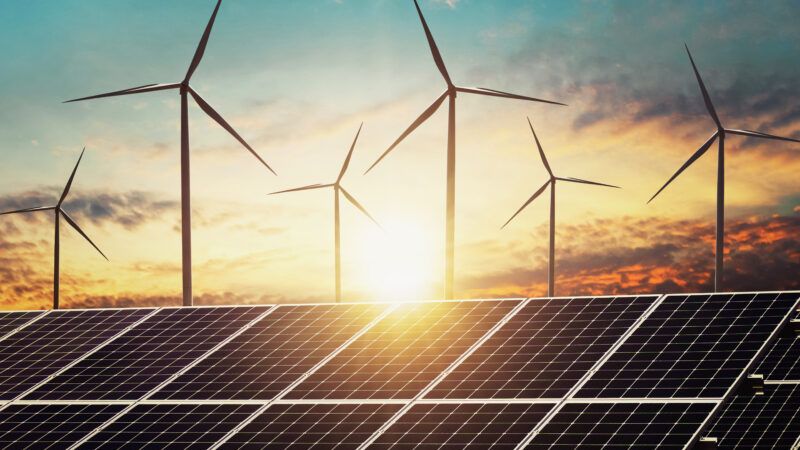 Wind turbines seen behind a solar panel | ID 141544934 © Lovelyday12 | Dreamstime.com