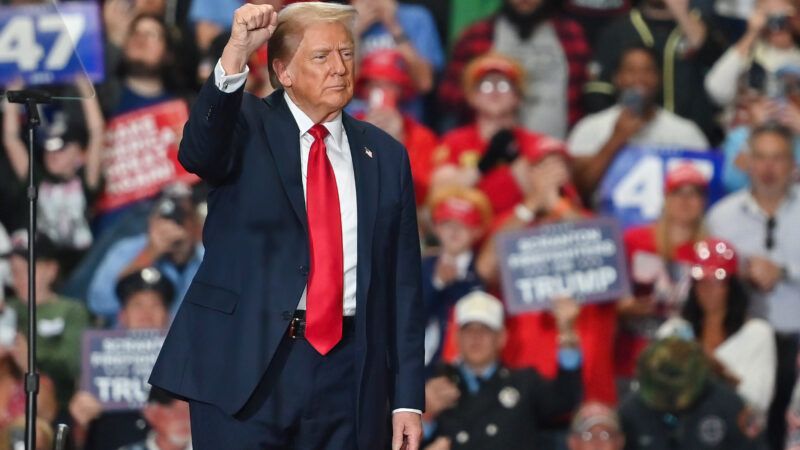 Former President Donald Trump raises his fist on stage at a rally. | Aimee Dilger/ZUMAPRESS/Newscom