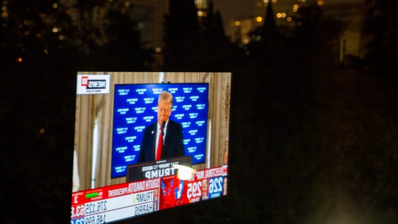 A news broadcast played on a screen shows Trump | Arash Khamooshi/Polaris/Newscom