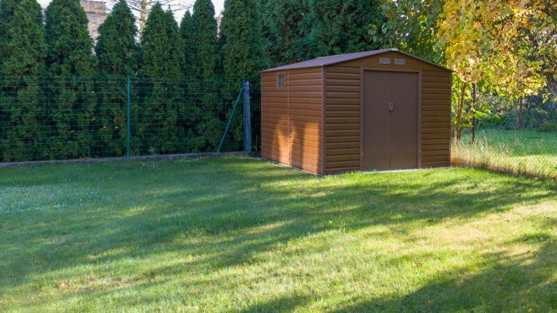 A wood-paneled garden shed in a backyard. | Adam Nowak | Dreamstime.com