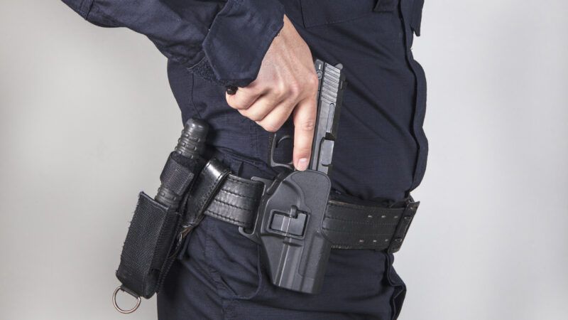 Close-up of a uniformed police officer's hand drawing his pistol from its holster. | Chatsimo | Dreamstime.com