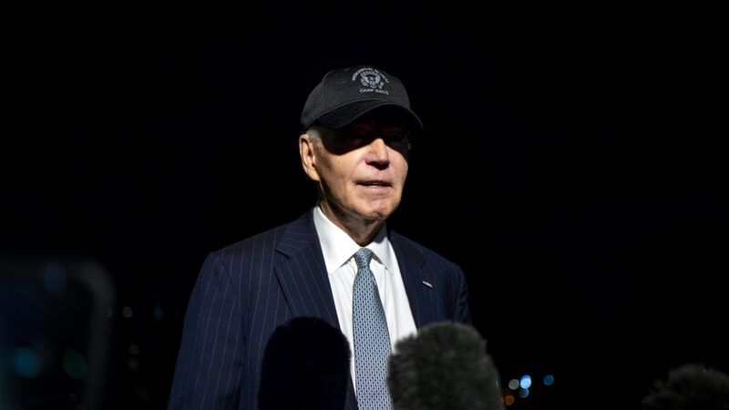 President Joe Biden takes questions from reporters, at night, wearing a baseball cap. | Bonnie Cash - Pool via CNP/CNP / Polaris/Newscom