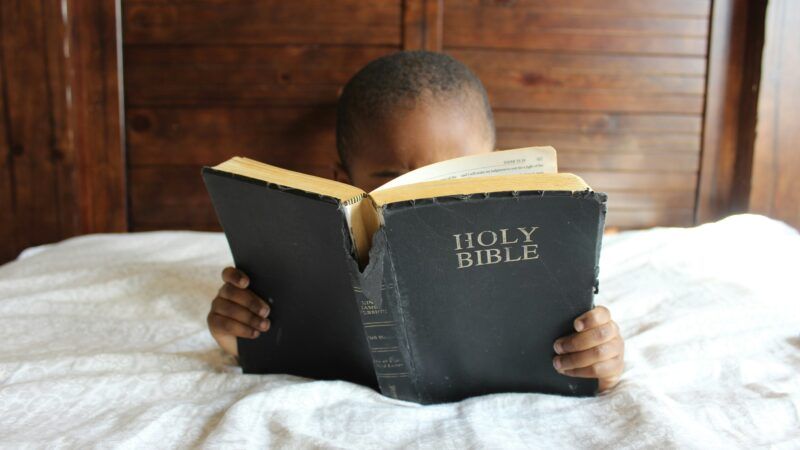 Person reading in the Bible in bed | Photo by <a href="https://unsplash.com/@samanthasophia?utm_content=creditCopyText&utm_medium=referral&utm_source=unsplash">Samantha Sophia</a> on <a href="https://unsplash.com/photos/boy-reading-holy-bible-while-lying-on-bed-NaWKMlp3tVs?utm_content=creditCopyText&utm_medium=referral&utm_source=unsplash">Unsplash</a>       