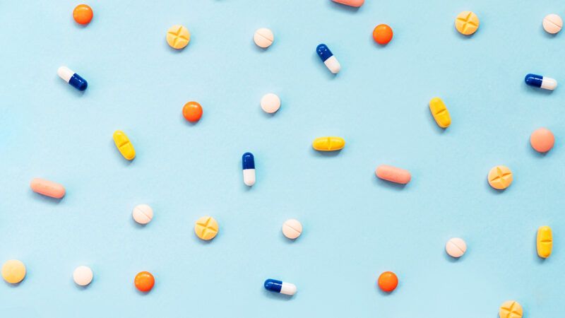 Tablets and capsules spread across a blue background | Photo: ediebloom/iStock