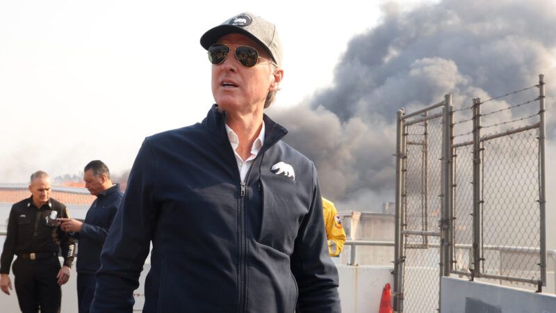 California Governor Gavin Newsom tours Pacific Palisades during the second day of the Palisades fire. Smoke and workers can be seen behind him. | Jonathan Alcorn/ZUMAPRESS/Newscom