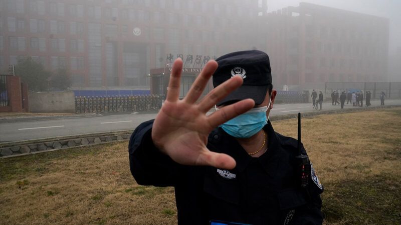 A Chinese law enforcement officer holding up his hand to obstruct the view of the camera | Photo: AP Photo/Ng Han Guan, File