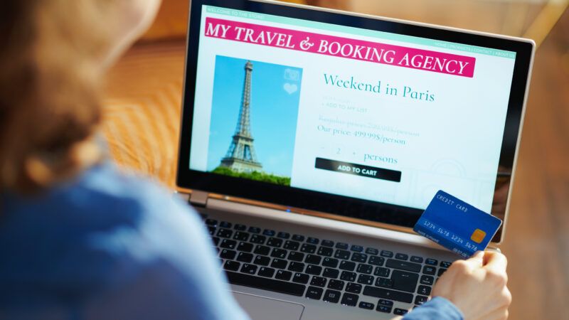 A woman holds a credit card while using her laptop; the screen depicts the Eiffel Tower, under the banner "My Travel & Booking Agency," and a listing for "Weekend in Paris." | <a href="https://www.dreamstime.com/woman-online-travel-site-laptop-holding-blue-credit-card-seen-above-young-opened-booking-agency-modern-home-image148986379">148986379</a> @ <a href="https://www.dreamstime.com/citalliance_info">Citalliance</a> | <a href="https://www.dreamstime.com/">Dreamstime.com</a>