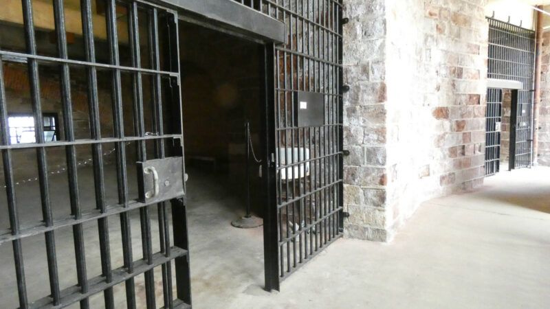 A prison cell in an old jail, with stone walls. | Bigapplestock | Dreamstime.com