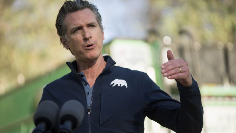 California Governor Gavin Newsom speaks into a microphone while standing outside | Sipa USA/Newscom