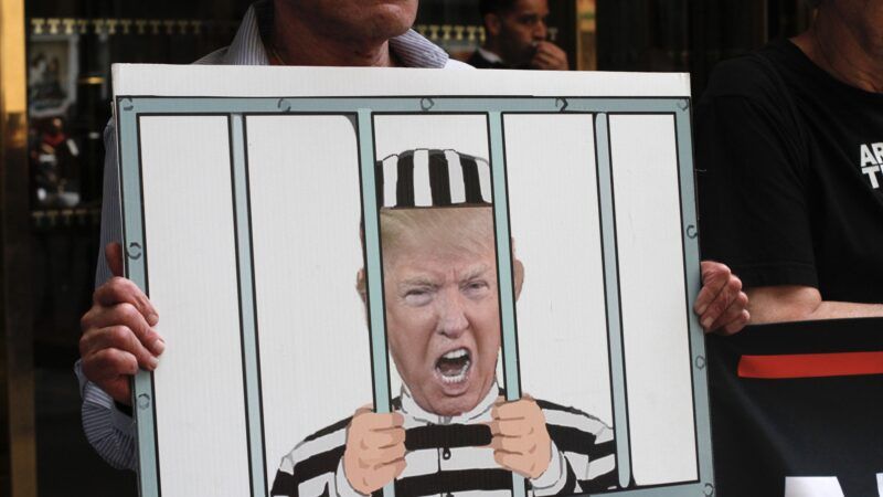 Protest sign that depicts Donald Trump in prison, wearing a black-and-white striped jumpsuit and hat. | Niyi Fote/ZUMAPRESS/Newscom