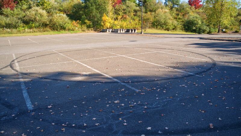 Circular skid marks in a parking lot that indicate someone was doing donuts. | Rtdeleon04 | Dreamstime.com