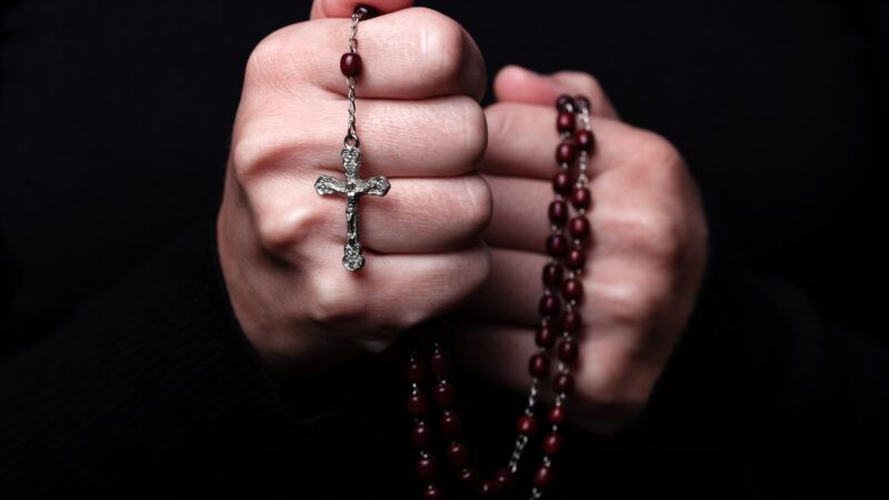 A woman's clasped hands hold a rosary with a crucifix, signifying that she is in prayer. | Zts | Dreamstime.com