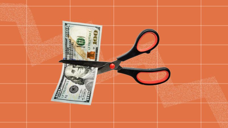 Pair of scissors cutting a 0 bill in half | Juan Marin Otero/Newscom