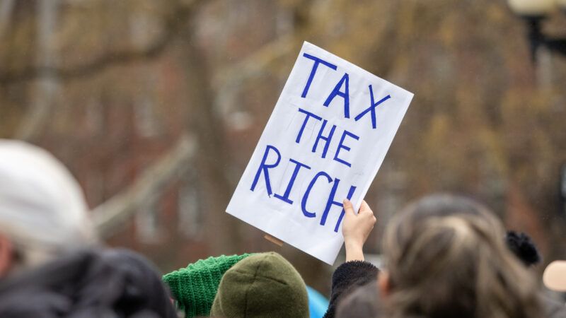 Protestor holds a sign that reads, "TAX THE RICH" | Carlos Chiossone/ZUMAPRESS/Newscom