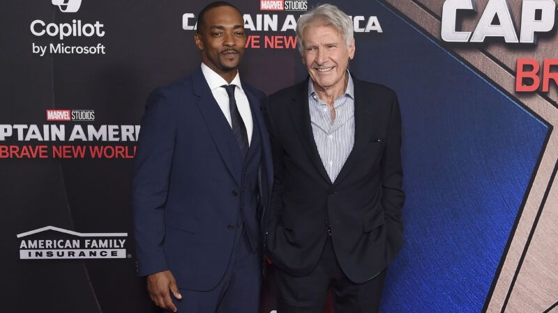 Actors Anthony Mackie and Harrison Ford standing in front of the Captain American premiere poster | Dave Starbuck/ZUMAPRESS/Newscom