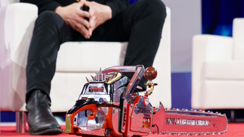 The chainsaw gifted to Elon Musk by Argentinian President Javier Milei, sitting at Musk's feet on the stage at the Conservative Political Action Conference. | Will Oliver - Pool via CNP/Newscom