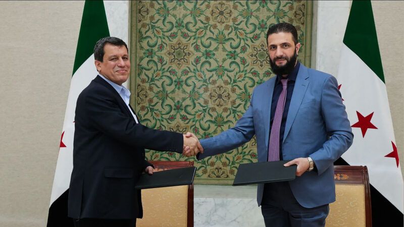 Syria's interim president Ahmed al-Sharaa shaking the hand of Syrian Democratic Forces (SDF) commander-in-chief Mazloum Abdi after the signing of an agreement in Damascus, Syria. March 10, 2025. | Syrian Arab News Agency (SANA)/UPI/Newscom