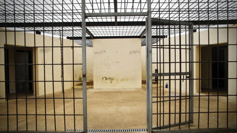 A jail holding cell with the door standing open. | First Name | Dreamstime.com