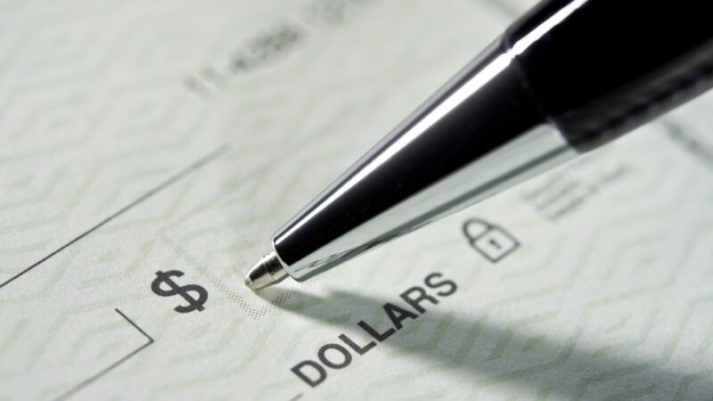 Close-up of a pen filling out a paper check. | Pictac | Dreamstime.com