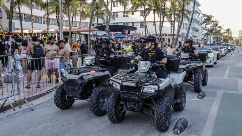 Miami Beach Police officers ride on all-terrain vehicles down a crowded street | Al Diaz/TNS/Newscom