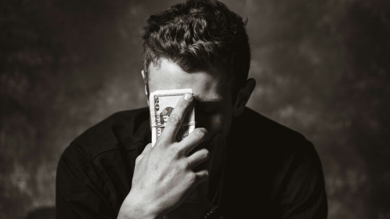 Man holding money up to his face | Photo by <a href="https://unsplash.com/@travisessinger?utm_content=creditCopyText&utm_medium=referral&utm_source=unsplash">Travis Essinger</a> on <a href="https://unsplash.com/photos/man-holding-banknote-cjeThQtJpaw?utm_content=creditCopyText&utm_medium=referral&utm_source=unsplash">Unsplash</a>       