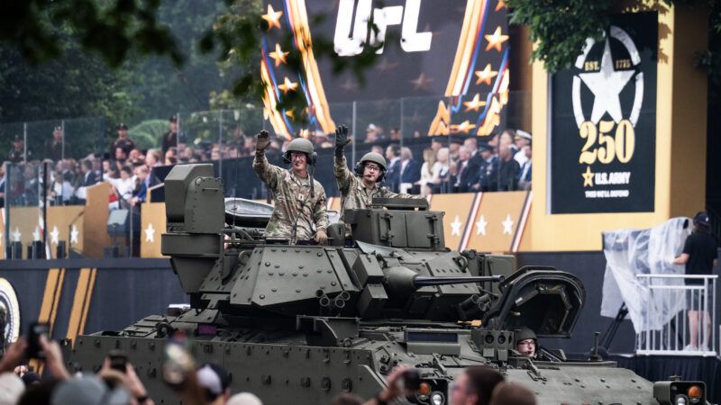 Troops wave from the top of a tank during the June 14, 2025 military parade in Washington, D.C. A giant UFC logo is visible in the background. | Tom Williams/CQ Roll Call/Newscom