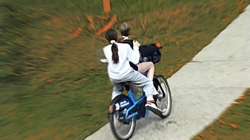 Two children riding on a bike. | Illustration: Eddie Marshall | Aspen Police Department