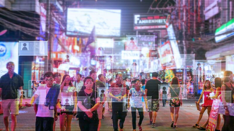 People walking down the street with a digital overlay of different screens across the image |  Piyamas Dulmunsumphun | Dreamstime.com