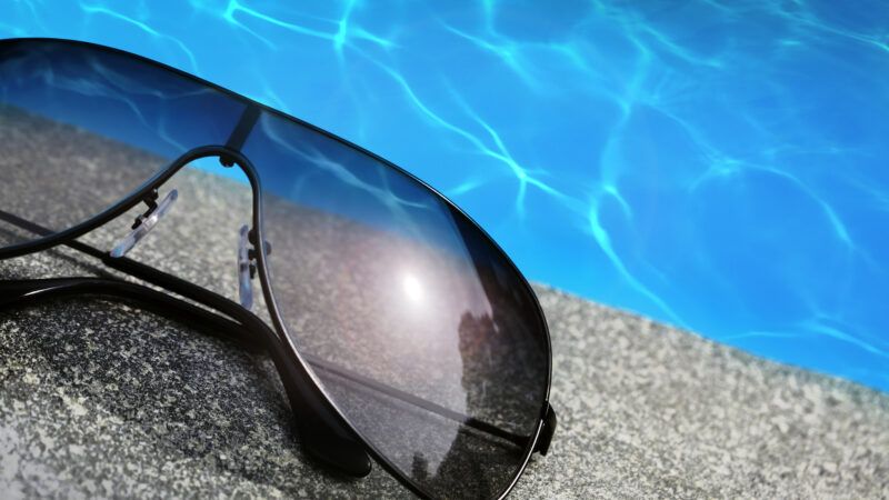 Close-up of sunglasses on the side of a pool, in summer. Close-up of sunglasses on the side of a pool, in summer. | Mikael Damkier | Dreamstime.com