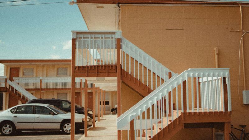 Motel | Photo by <a href="https://unsplash.com/@caviking101?utm_content=creditCopyText&utm_medium=referral&utm_source=unsplash">Andrew Karn</a> on <a href="https://unsplash.com/photos/two-vehicles-parked-in-front-of-establishment--yZjegM0sUw?utm_content=creditCopyText&utm_medium=referral&utm_source=unsplash">Unsplash</a>       