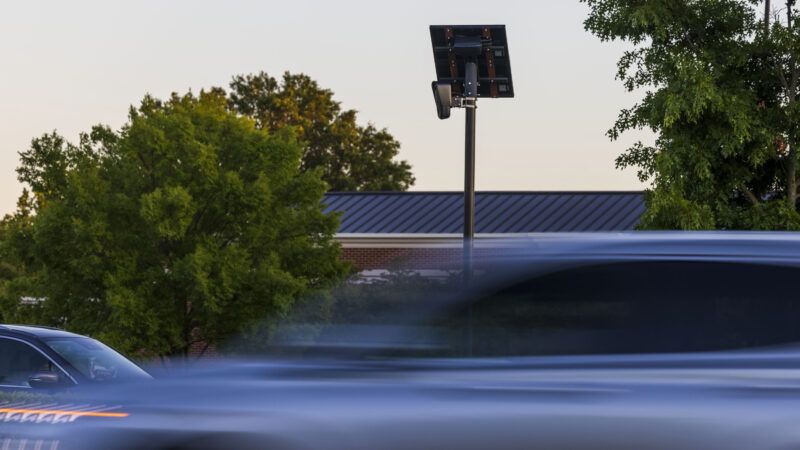 Traffic drives by an automated license plate reader (ALPR) mounted high on a roadside pole. | Kendall Warner/TNS/Newscom