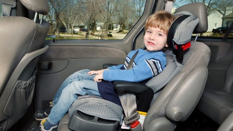 A toddler sits in his car seat in the back of a car. | Suzanne Tucker | Dreamstime.com