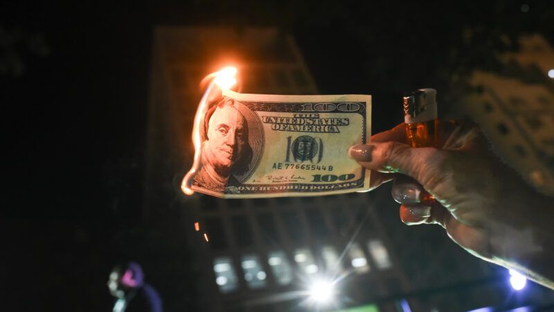 Hundred dollar bill on fire | Fabio Teixeira/ZUMAPRESS/Newscom