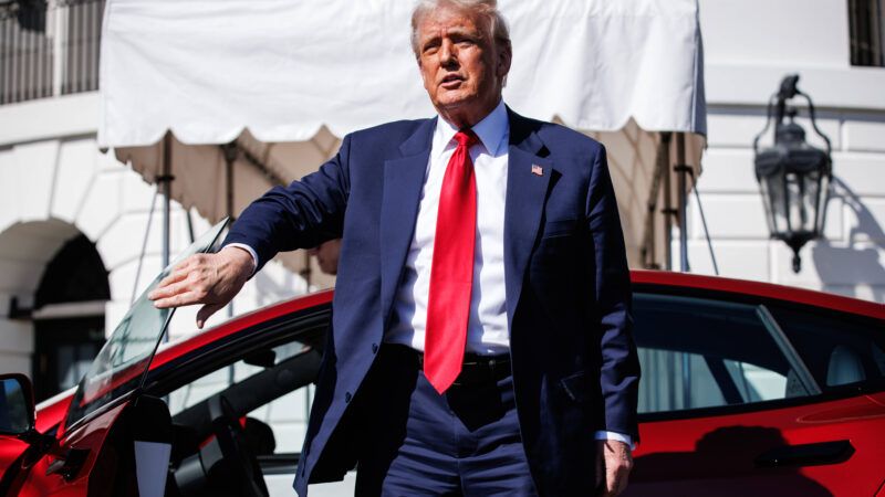 President Donald Trump stands next to a red Tesla Model S on the South Lawn of the White House. | CNP/AdMedia/SIPA/Newscom