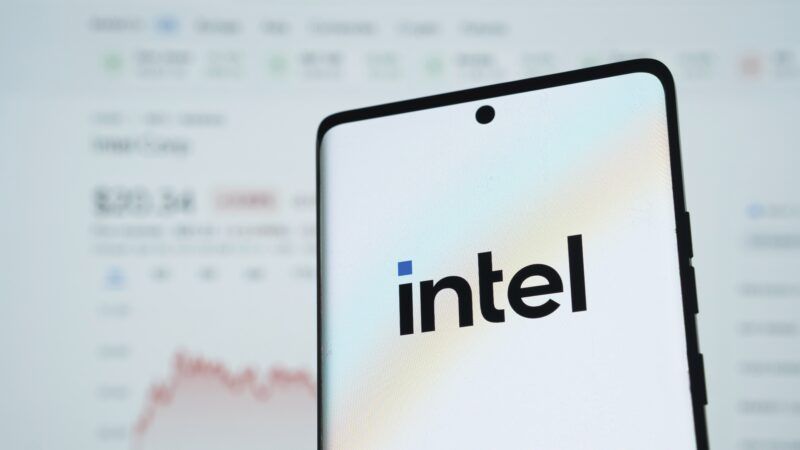The intel logo is seen on a phone in front of a stock report | imageBROKER/Md Mamun Miah/Newscom