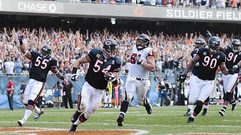 A player in a Chicago Bears uniform runs into the end zone with the ball, tailed by several teammates and an opponent in the white jersey. Fans in the background have their hands in the air. | Nuccio DiNuzzo/TNS/Newscom