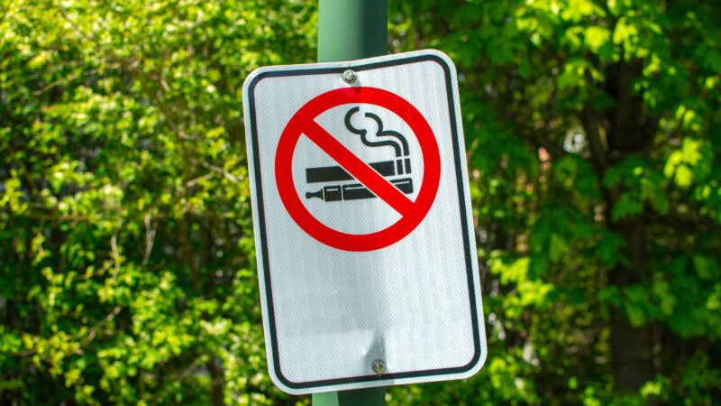 A "No vaping" road sign, showing a diagram of an e-cigarette with a circle and line through it | Bakerjarvis | Dreamstime.com