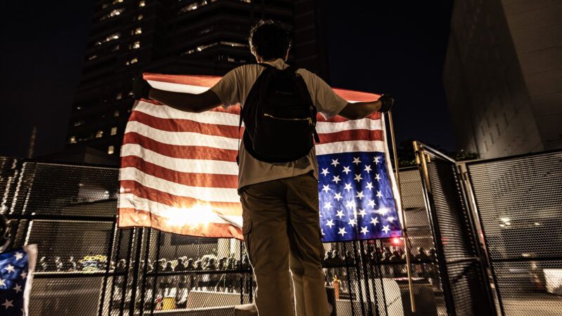 A man holds up an upside-down American flag at an ICE protest | Ted Soqui/Sipa USA/Newscom