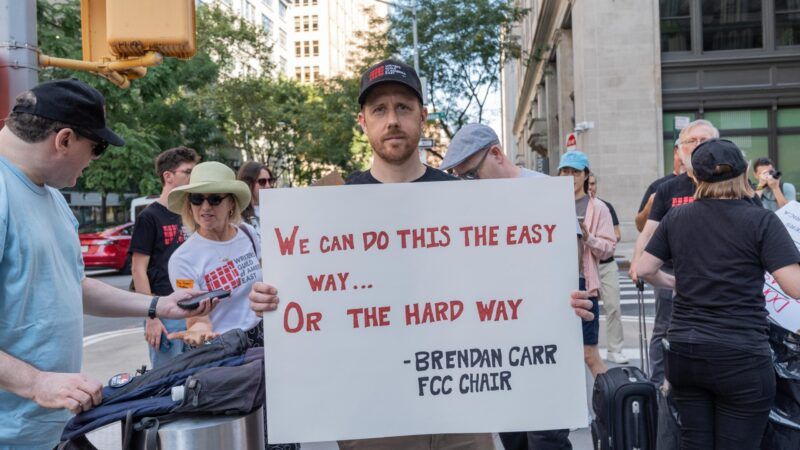Protester holding Brendan Carr sign | Lev Radin/ZUMAPRESS/Newscom