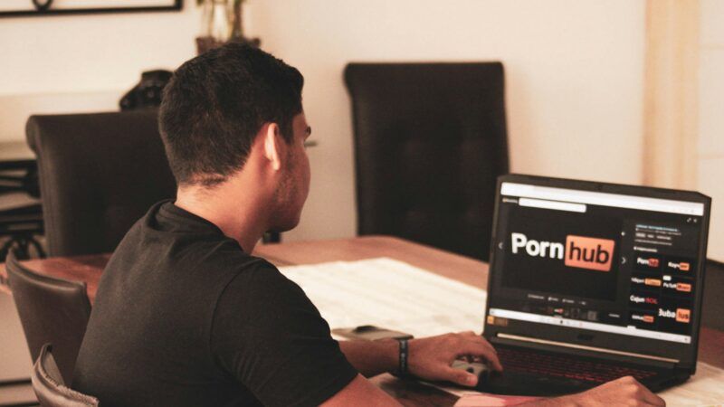 A man on the Pornhub website on his laptop | Photo by <a href="https://unsplash.com/@dreamyframing?utm_source=unsplash&utm_medium=referral&utm_content=creditCopyText">franco alva</a> on <a href="https://unsplash.com/photos/man-in-black-t-shirt-using-black-laptop-computer-aqFzxyC3rf8?utm_source=unsplash&utm_medium=referral&utm_content=creditCopyText">Unsplash</a>       