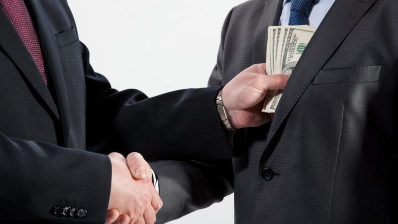 Two men in business suits shake hands, while one places cash in the other's jacket pocket. Two men in business suits shake hands, while one places cash in the other's jacket pocket. | Zestmarina | Dreamstime.com