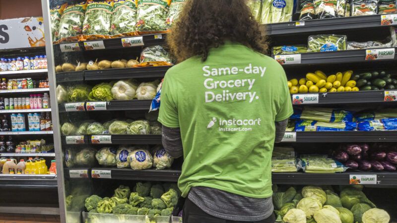 A person with a green shirt looks at a grocery store produce cooler | Richard B. Levine/Newscom