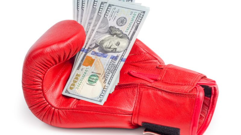 A boxing glove with a handful of U.S. 0 bills. | Zaclurs | Dreamstime.com