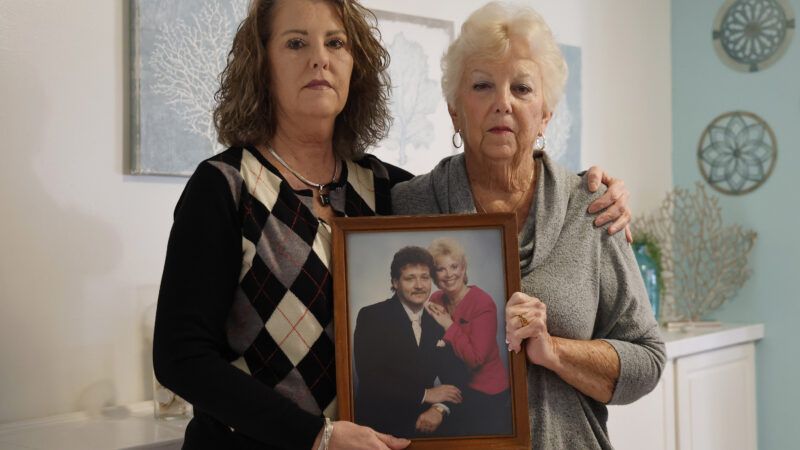 Paul John Bojerski's wife, Gayle Bojerski, and her daughter hold a photo of Paul and Gayle. | Ricardo Ramirez Buxeda/TNS/Newscom
