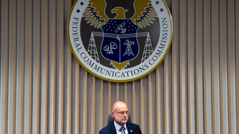 Brendan Carr sitting beneath the FCC seal | Photo: Federal Communications Commission Chairman Brendan Carr; Kent Nishimura/Bloomberg/Getty