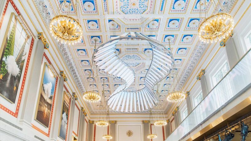 A bright and ornate room with paintings, chandeliers, and fancy ceiling tiles | Milken Center for Advancing the American Dream